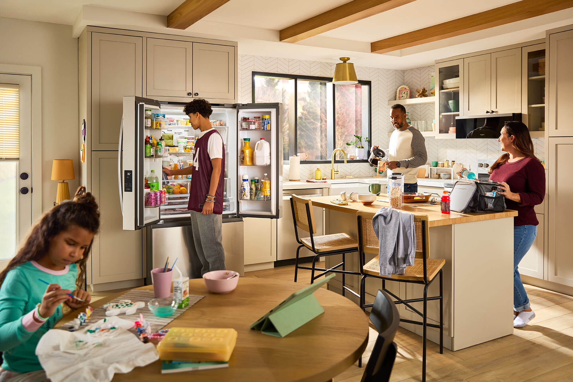 Image of a family in a kitchen using whirlpool refrigerator